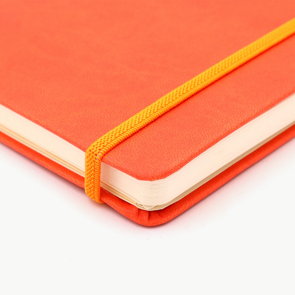 Orange notebook with a yellow strap on a white background